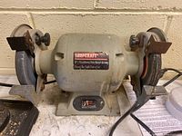 Front view showing entire Shopcraft bench grinder with dual grinding wheels and on/off switch.