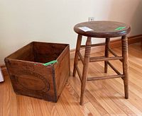 Photo showing both the wooden stool with lathed legs and the Canadian Butter wood crate side by side on a hardwood floor.