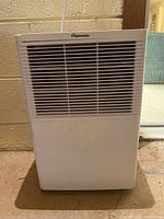 Front view of white Fridgemaster dehumidifier showing vented front panel and minor surface dirt.