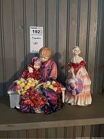 Both figurines side by side on shelf