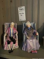 Both figurines front view, seated in armchairs