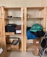 Two wooden shelving units side by side with various storage items on and around them, showing overall structure and height.