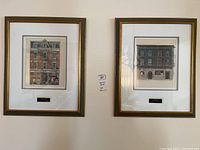 Two framed prints on a wall, side by side, showing historic Toronto buildings.