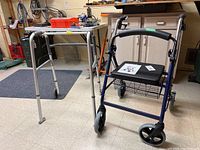 Aluminum folding walker and blue wheeled walker side by side in basement area