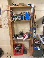 Full front view of the wooden shelving unit filled with various items showing overall condition and dimensions.