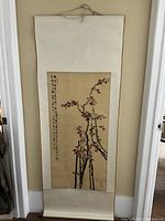 Full view of the Chinese scroll painting hanging on wall, showing cherry blossoms and calligraphy