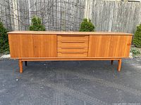 Front view of full sideboard showing two side doors and central bank of four drawers