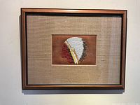 Full view of framed quill artwork hanging on wall
