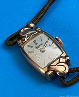 Dial and case detail showing Supreme logo on white dial, gold-tone numerals, swirled rose gold lugs