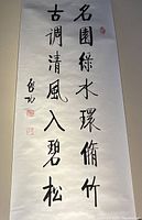 Full view of unframed calligraphy scroll showing four columns of black ink script on paper