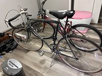 Side view of men's Raleigh Marathon road bicycle showing black and gray frame, drop handlebars, and tires needing air.