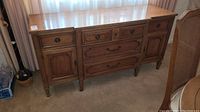 Front view of vintage wooden buffet cabinet showing drawers and cabinet doors.