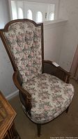 Full view of the chair showing floral upholstery with wooden frame and cane side panels.