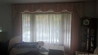 Full view of curtain window treatment showing peach drapes with lined fabric and off-white sheer curtains underneath with scalloped valance.