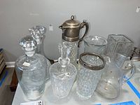 Overview of all glass decanters, pitchers, and vases showing diversity in shapes and textures