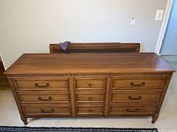 Front view of dresser showing nine drawers with metal handles