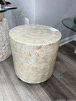 Front and side angled view of cylindrical side table covered in mother of pearl.