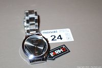 Front angle of the Bariho men's wristwatch showing stainless steel bracelet, triangular dial design, and tag.