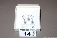Blue topaz necklace and earrings set displayed in a white box with MaxSold label.