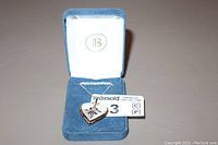 Heart-shaped sterling silver necklace pendant with a blue sapphire stone displayed inside a blue velvet necklace box with white interior and Bradford Exchange logo.