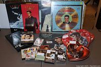 Wide view showing entire lot including cassette sets, LP records, and heart-shaped tins.