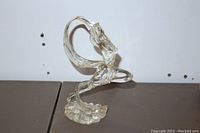 Side angled view showing the clear Lucite woman figurine with extended arm and curved flowing shape.