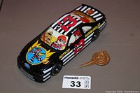 Black and white striped vintage McDonald's Hot Rod racing car bank with number 13 and character illustrations. Key is shown beside the bank.