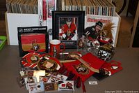 Photo of assorted Ottawa Senators memorabilia items including cards, mugs, scarf, framed photo, photo album, coasters, and a small helmet figurine.