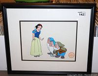 Framed Snow White sterigraph artwork showing Snow White and two dwarfs with visible Walt Disney Sterigraph stamp on front. Frame is black with white matting.