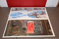 Two unframed Star Wars McQuarrie concept prints laid flat, showing full length side-by-side views. One print depicts AT-AT walkers on a snowy battlefield with snowtroopers. The other print shows characters observing a red holographic projection inside a futuristic room.