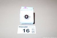Front view of sterling silver ring with dark red stone on white display stand and lot tag
