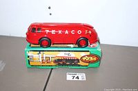 Front-side view of Texaco Doodlebug tanker bus toy placed on top of its original box showing the logo and detailed design.
