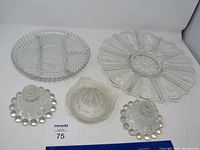 Full lot showing two glass platters, citrus juicer, and two candle holders on white background with ruler for scale.