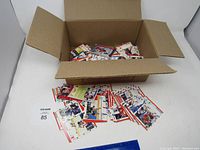 Open cardboard box filled with loose hockey cards. Some cards displayed outside the box to show condition and artwork.