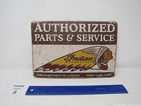 Full view of the Indian Authorized Parts & Service metal sign with ruler for scale.