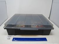 Black closed plastic container with a translucent lid and handle, standard size indicated by a 12-inch ruler for scale.