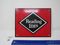 Front view of one porcelain sign with red background and Reading Lines logo in black diamond with white text, measuring about 12 inches wide.