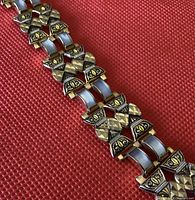 Close-up of Damascene bracelet showing detailed yellow enamel patterns and Mother of Pearl inlays on linked sections.