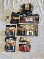 Photo showing an assortment of Duracell batteries including AAA, AA, 9V, and coin cells in original packaging.