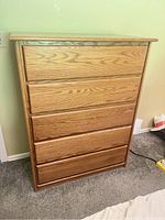 Front view of solid oak 5-drawer dresser chest showing drawer fronts and color.