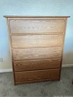 Front view of the solid oak dresser chest showing five drawers and clean furniture condition.
