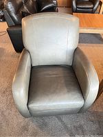 Frontal view of a grey leather armchair showing the seat, armrests, and backrest.