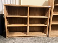 Front view of the oak bookshelf showing two vertical dividers and six shelf areas.