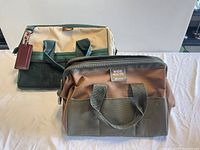 Front view of two tool bags: Kunys bag in tan and green with mesh pockets and Superex Wide Mouth bag in tan with green base.