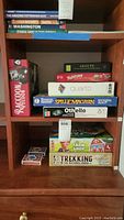 Shelf with stacked board games and playing cards visible