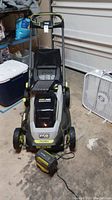 Full view of mower with battery in charger on concrete floor
