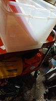 White plastic storage bin on red metal cart