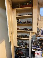 Wide view of cupboard shelves stacked with assorted hand tools, drivers, pliers, and wrenches.