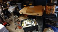 Workbench area showing lathe and two wooden chisel cases amid workshop items