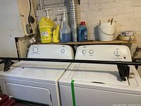 Washer and dryer side by side with laundry supplies and car rack (rack not included) on top